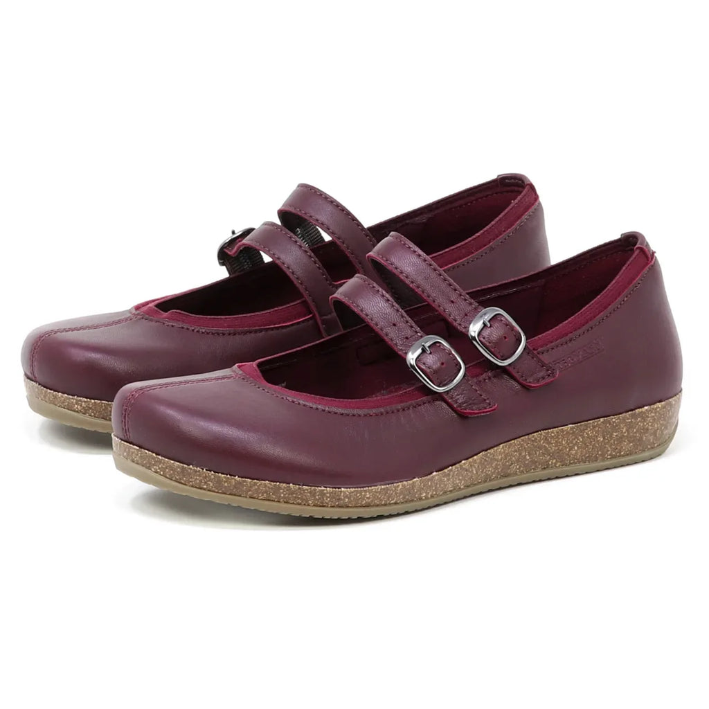 The Women's Marielle Leather Mary-Jane shoes in burgundy stretch leather feature two buckle straps and cork-textured soles, displayed on a white background.