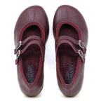 A pair of Women's Marielle Stretch Leather Mary-Jane shoes in maroon, featuring double buckle straps and arch support, is displayed from above on a white background.