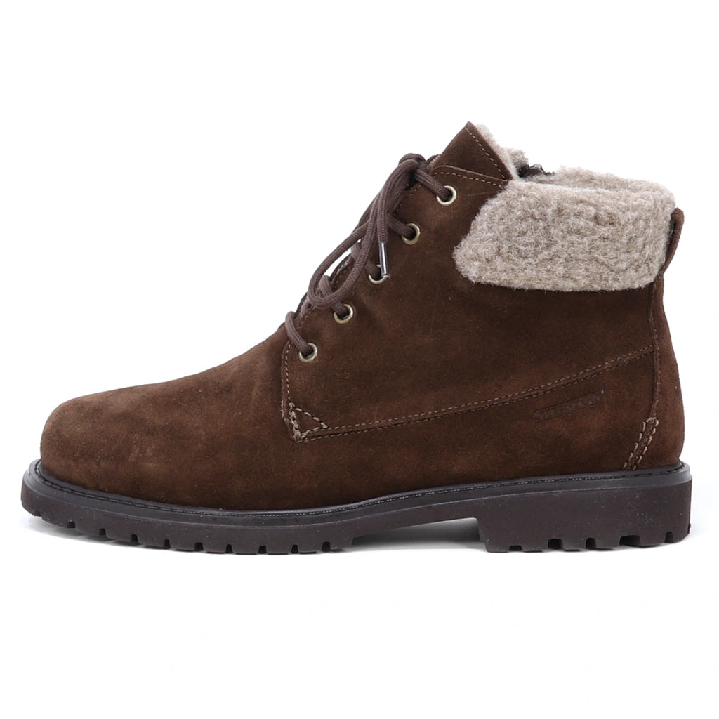 Women’s Merano Chukka Boot in brown waterproof suede, featuring a lace-up design, thick rubber sole, and light brown faux fur lining around the ankle. Shown in left side profile against a white background, this stylish chukka offers comfort and durability for cold-weather wear.
