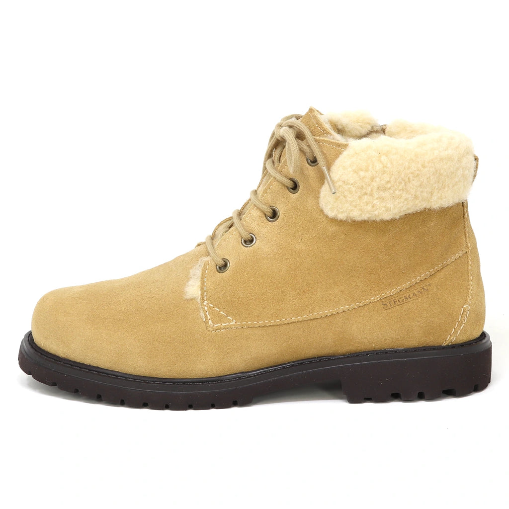 Women’s Merano Chukka Boot in tan suede with a beige faux fur collar, wool shearling winter styling, and a dark brown lugged rubber sole.