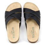 The Women's Romy Slide Sandal features black crisscross leather straps, a contoured cork footbed for comfort, and Stegmann branding on the insoles.