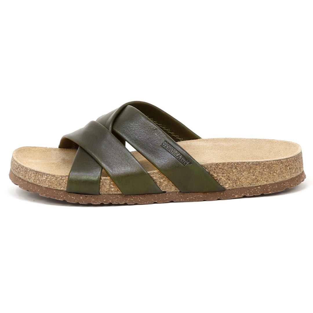 The Women's Romy Slide Sandal in green leather features criss-cross straps and a contoured cork footbed for comfort, shown from the side.