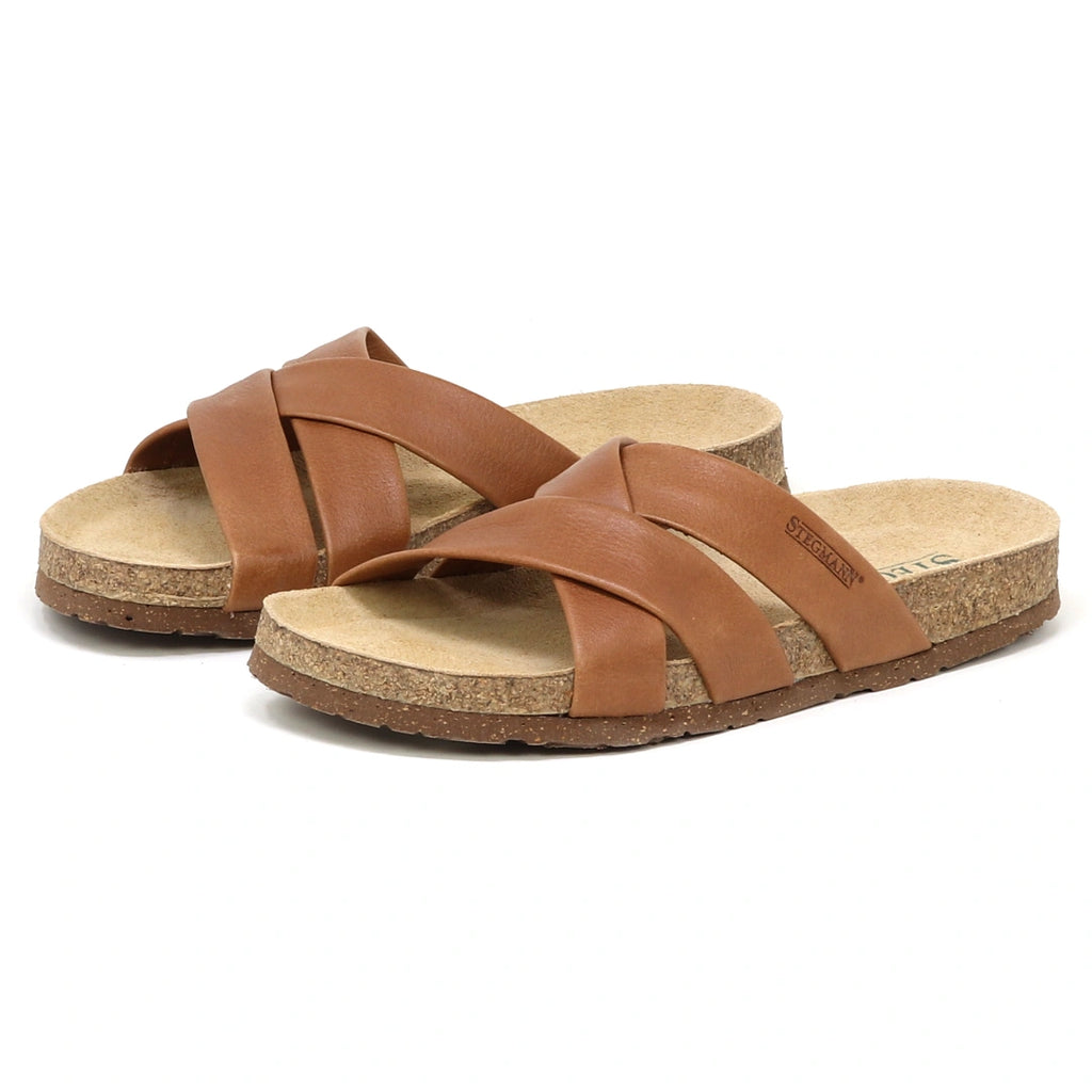 The Women's Romy Slide Sandal features brown leather crisscross straps and a contoured cork footbed for comfort, displayed on a white background.