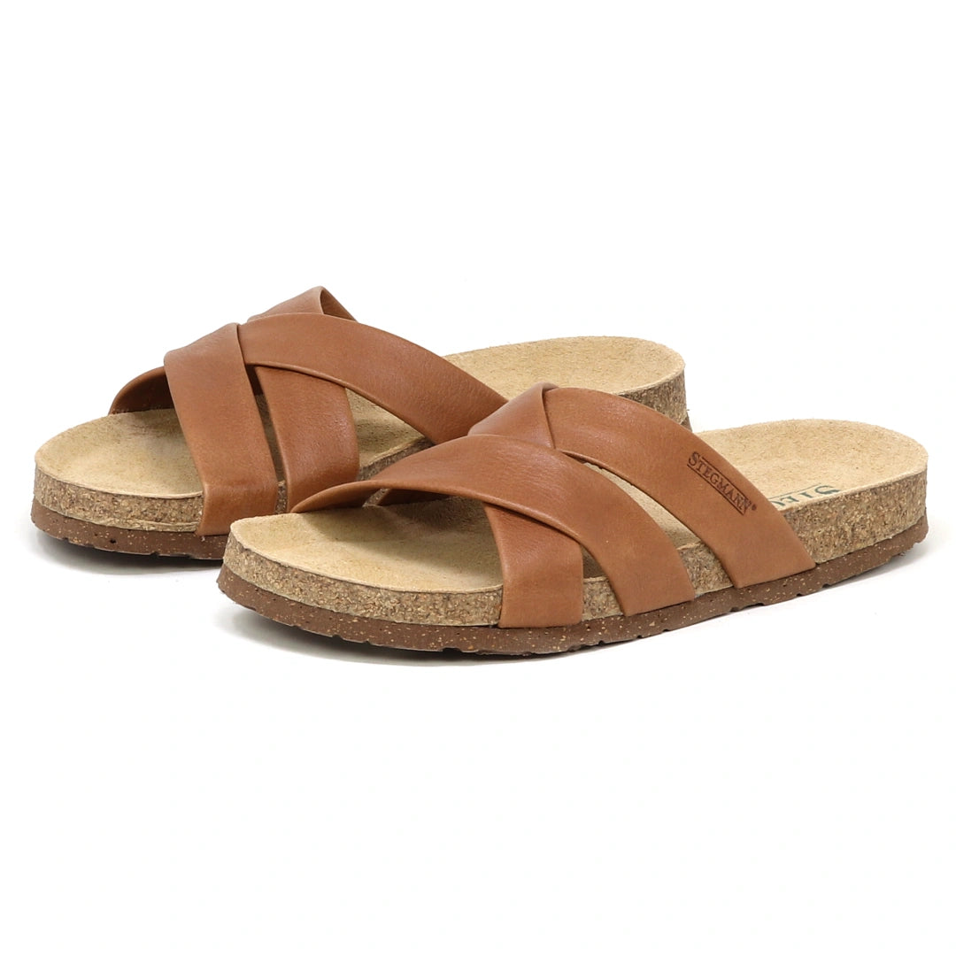 The Women's Romy Slide Sandal features brown leather crisscross straps and a contoured cork footbed for comfort, displayed on a white background.