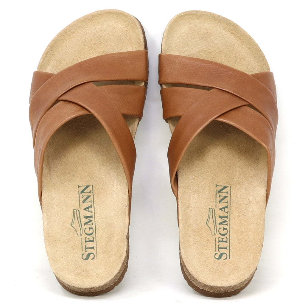 The Women's Romy Slide Sandal features brown leather crisscross straps, a contoured cork footbed for comfort, and displays the Stegmann logo.