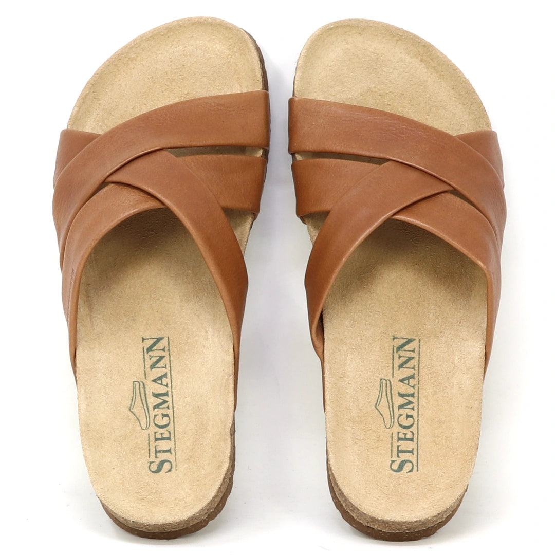 The Women's Romy Slide Sandal features brown leather crisscross straps, a contoured cork footbed for comfort, and displays the Stegmann logo.