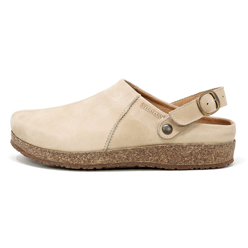 The Women's Tirol Leather Clog is a beige open-back design made from oiled leather, featuring a wide toe box, an adjustable strap, and a cork sole.