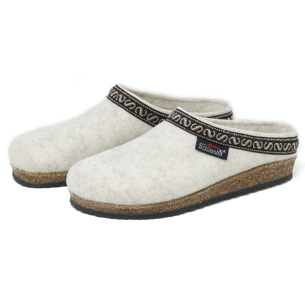 The Women's Original 108 Vegan Wool Clog in gray showcases black soles and a decorative trim around the opening. Made as a sustainable shoe using recycled polyester, they effortlessly blend style with eco-consciousness.