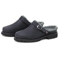 A pair of Zermatt Wool Shearling Clogs in black, designed as backless slip-ons with grey faux fur lining that mimics classic wool shearling, featuring a side buckle strap and rugged rubber soles.