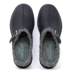 The Zermatt Wool Shearling Clog is shown from above—a pair of black slip-on clogs featuring a wool shearling lining and buckle detail on the left shoe.