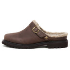 The Zermatt Wool Shearling Clog is a brown leather slip-on featuring a cozy wool shearling lining, an adjustable buckle strap, and a black rubber sole, delivering the warmth and comfort typically found in lightweight winter boots.