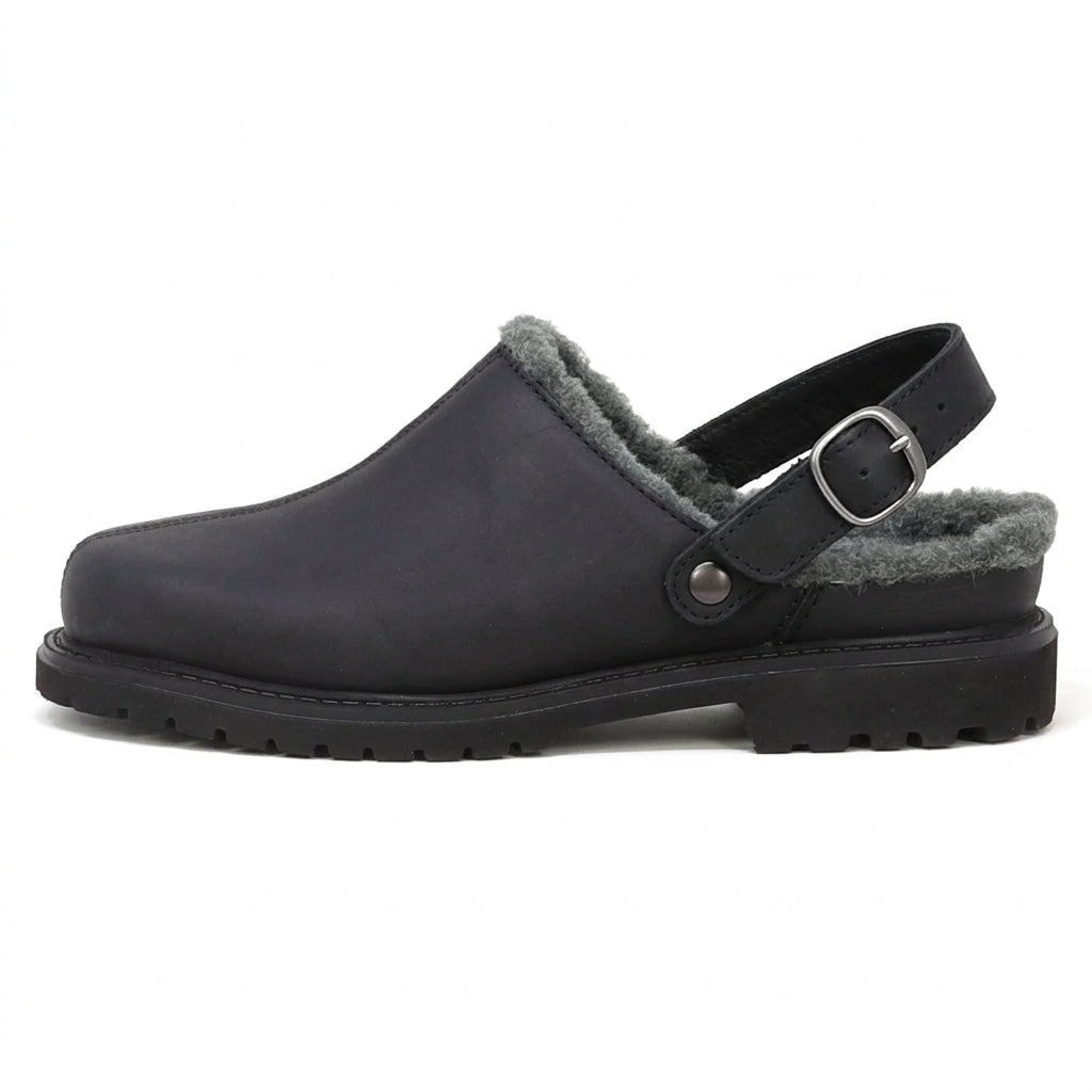The Trento Wool Shearling Clog is a black, vegetable-tanned leather winter clog with grey fleece lining, buckle strap, and thick treaded sole in side profile view.