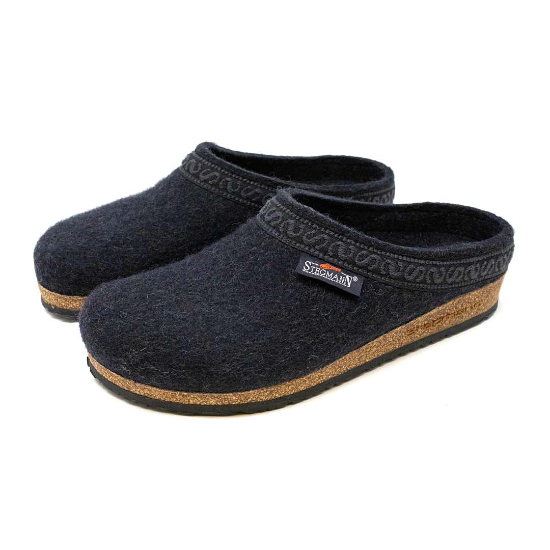 Introducing the Women's Original 108 Wool Clog - Wide, designed with black Merino wool felt and featuring a brown cork support sole, along with a decorative pattern along the rim.
