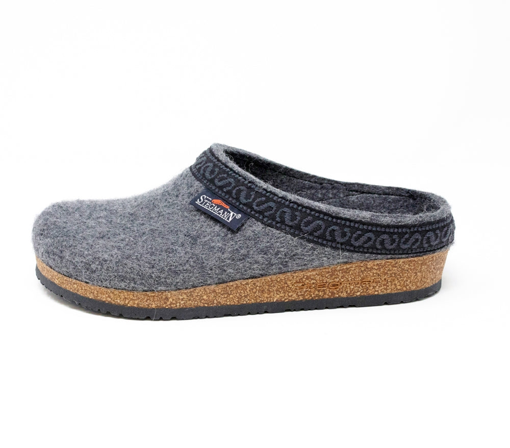 The Women's Original 108 Wool Clog - Wide is a chic footwear option made from premium Merino wool felt, featuring a singular gray clog adorned with patterned trim and supported by a cork sole, all showcased against a plain white backdrop.