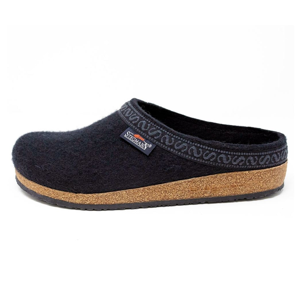 The Men's Original 108 Wool Clog is a black felt slipper designed for men, featuring a supportive cork sole, decorative trim on the upper edge, and luxurious Merino wool for enhanced comfort.