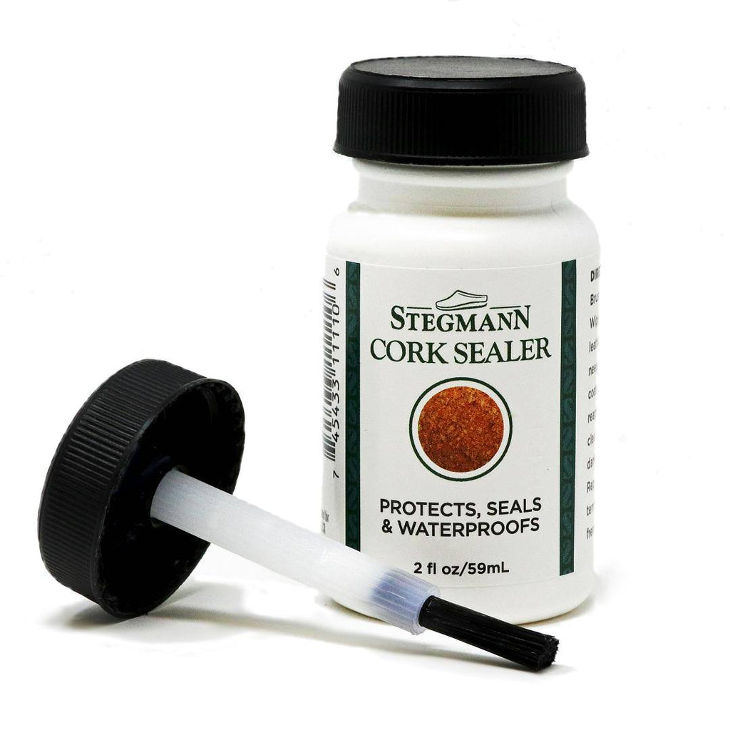 The Wool & Cork Care Kit - Brush & Sealer, perfect for maintaining your Stegmann clogs, features an open brush applicator. The label reads "Protects, Seals & Waterproofs," ensuring your footwear stays in top condition.
