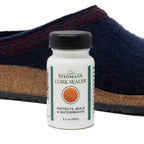 A Stegmann Cork Sealer bottle stands before a blue wool shoe with cork sole, promising to "Protect, Seal & Waterproof," keeping footbeds pristine.