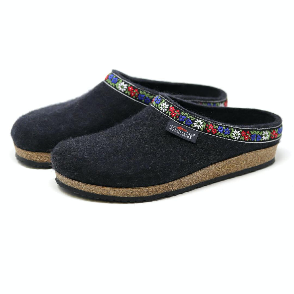 Women's Edelweiss Wool Clogs in dark felt feature cozy Merino wool, cork soles, and a vibrant embroidered floral band around the opening, displayed against a plain background.