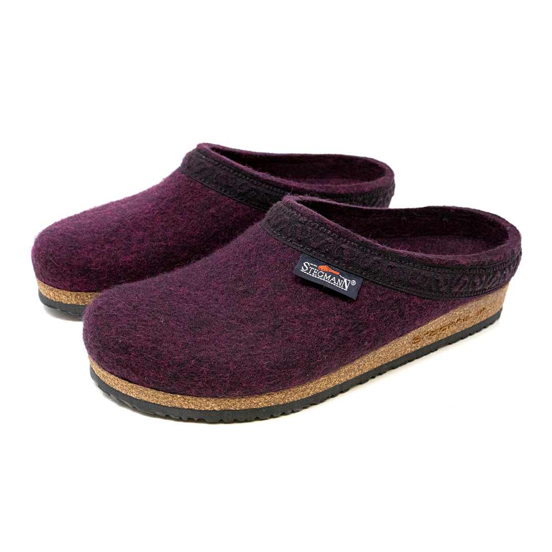 The Women's Original 108 Wool Clog in purple, constructed from Merino wool felt, showcases a sophisticated black trim and a cozy cork and latex sole.