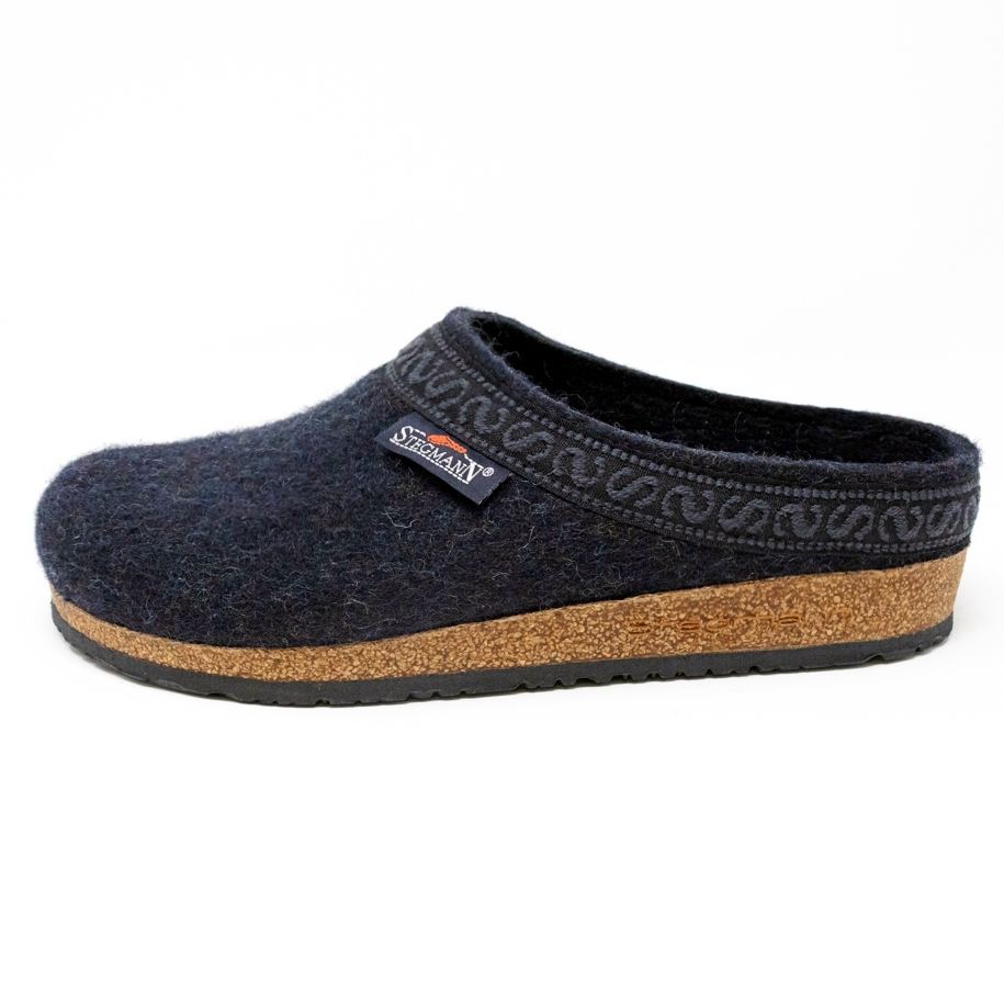 A side view of the Women's Original 108 Wool Clog - Wide, featuring a navy color with Merino wool felt and a cork support sole, complemented by decorative trim.