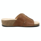 The Women's Layna Leather Wedge Sandal showcases a brown leather slide with an open toe and sustainable cork midsole, complete with a cushioned suede footbed for comfort, elegantly photographed from the side on a plain background.