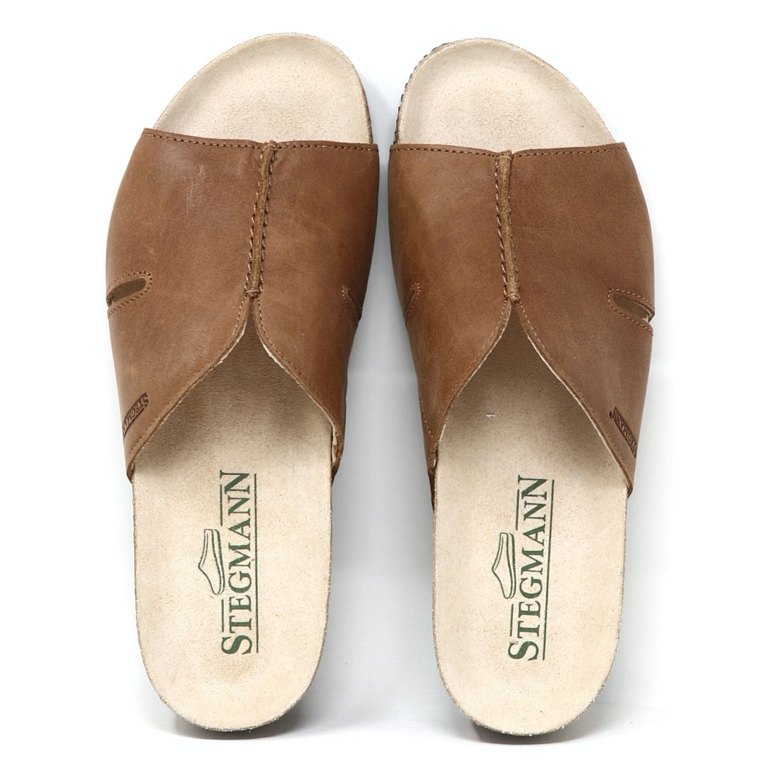 Women's Layna Leather Wedge Sandal is a brown leather slip-on featuring a sustainable cork midsole and "Stegmann" printed on the beige insoles.