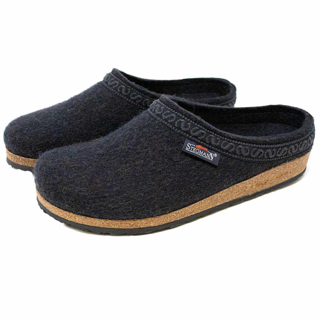 The Men's Original 108 Wool Clog in dark gray is crafted from soft Merino wool and features a supportive cork sole with black trim. Adorned with a small logo tag on the side, these clogs offer style and comfort in every step.