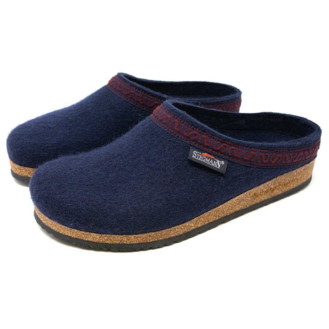 The Men's Original 108 Wool Clog features a navy design with red trim and a supportive cork sole, making it an ideal addition to a stylish men's shoe collection.