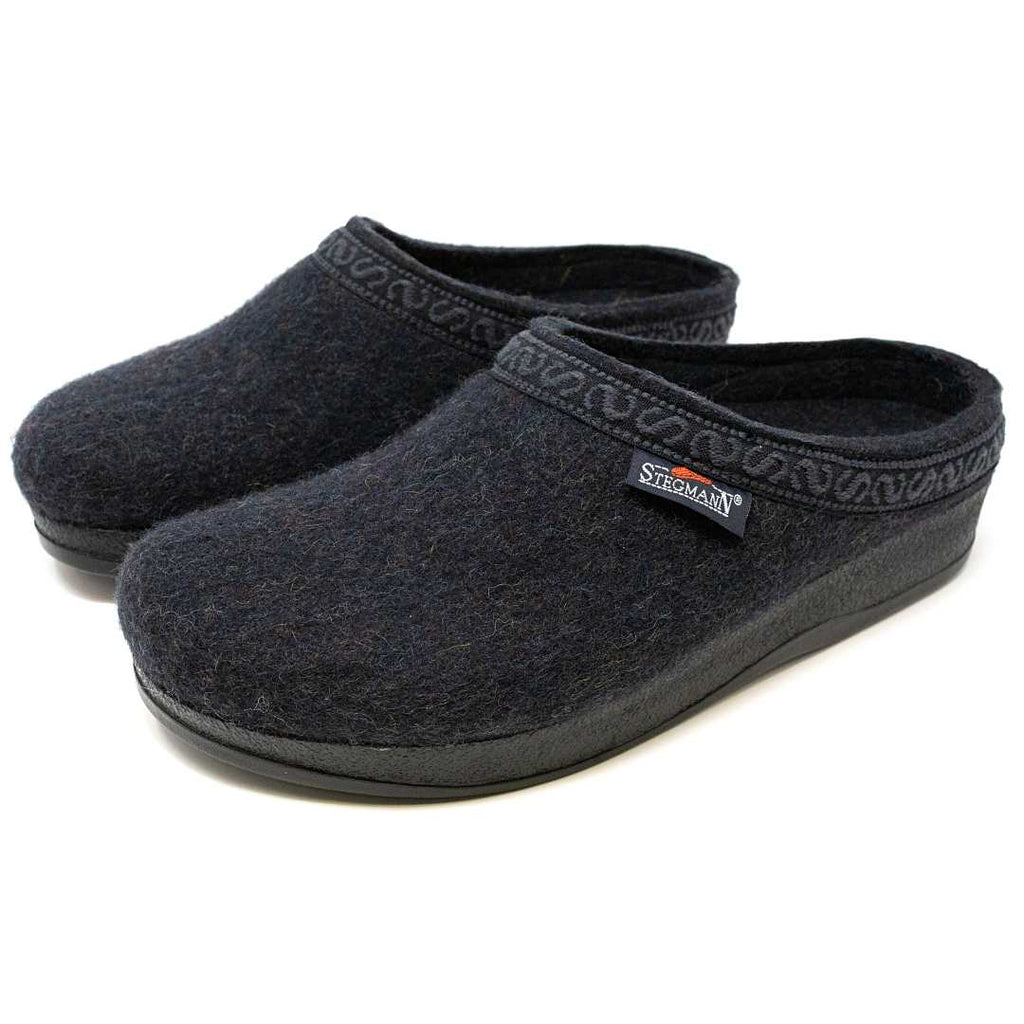 The Men's WoolFlex Wool Clog offers comfort and support with black Merino wool, decorative trim, rubber soles, a side brand label, and enhanced arch support.