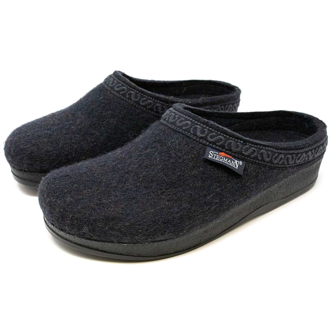 The Men's WoolFlex Wool Clog offers comfort and support with black Merino wool, decorative trim, rubber soles, a side brand label, and enhanced arch support.