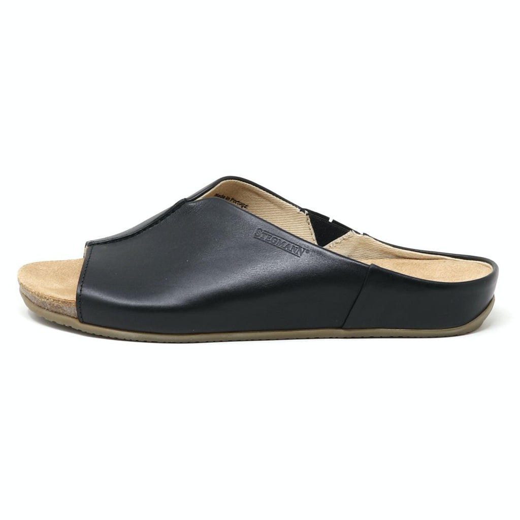 The Women's Mia Leather Slide Sandal is a black slip-on with an open-toe design, boasting a minimalist leather upper and a padded suede footbed for enhanced comfort.
